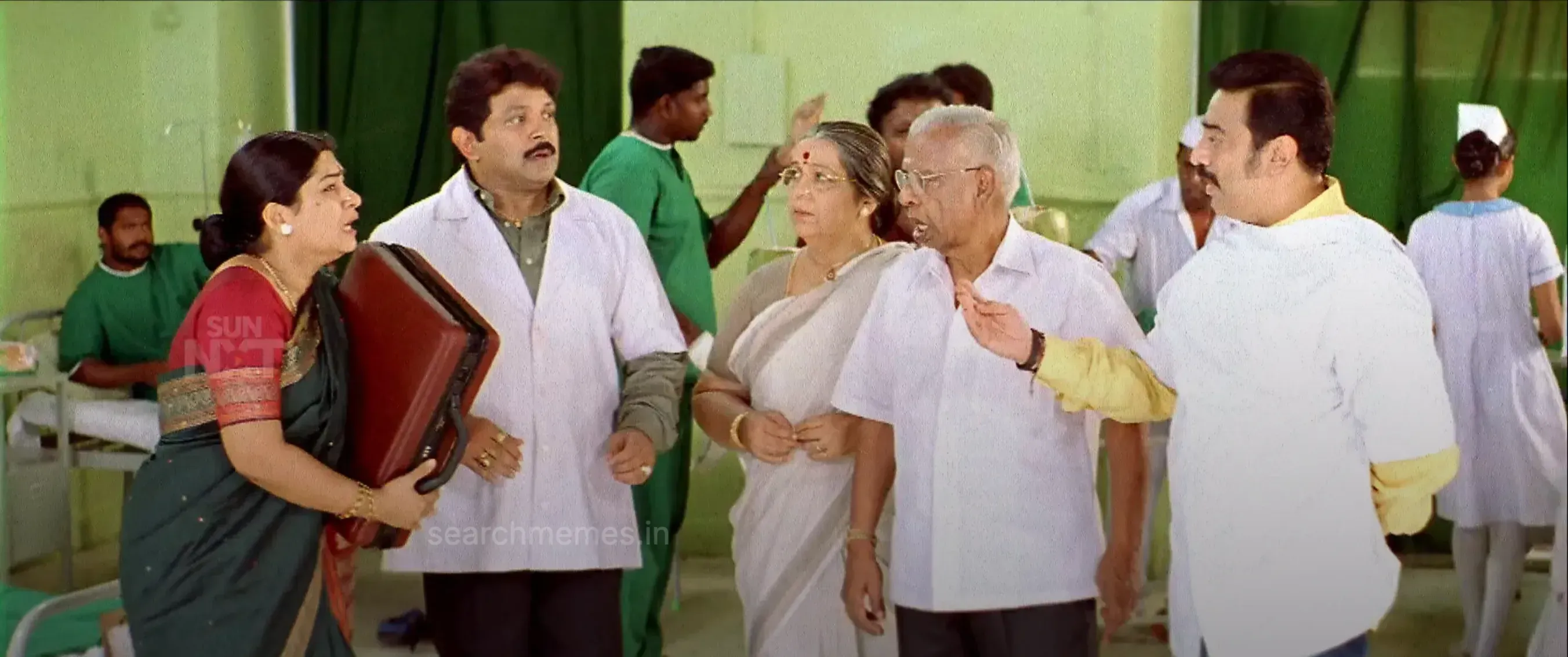 Kamal Haasan wearing a doctor coat gesturing in exasperation towards relatives