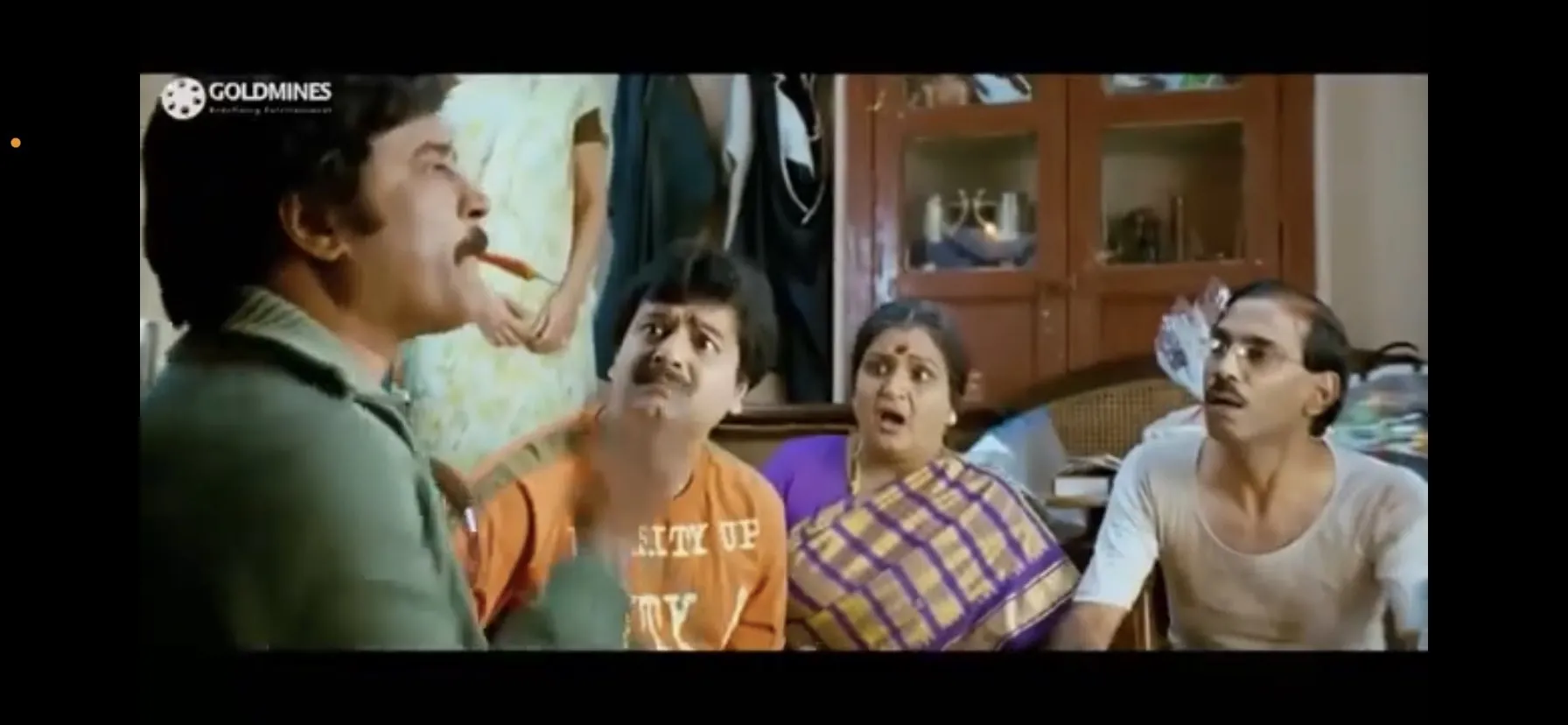 Rajinikanth chewing a green chilli while Vivek and family watch in utter disbelief