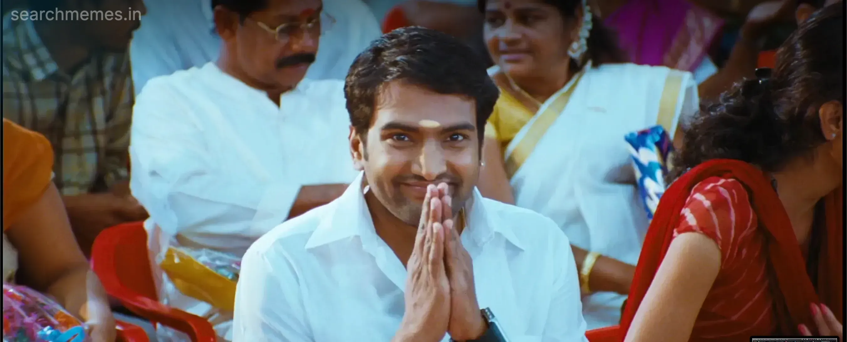 Santhanam folding his hands in a traditional vanakkam greeting with a smile