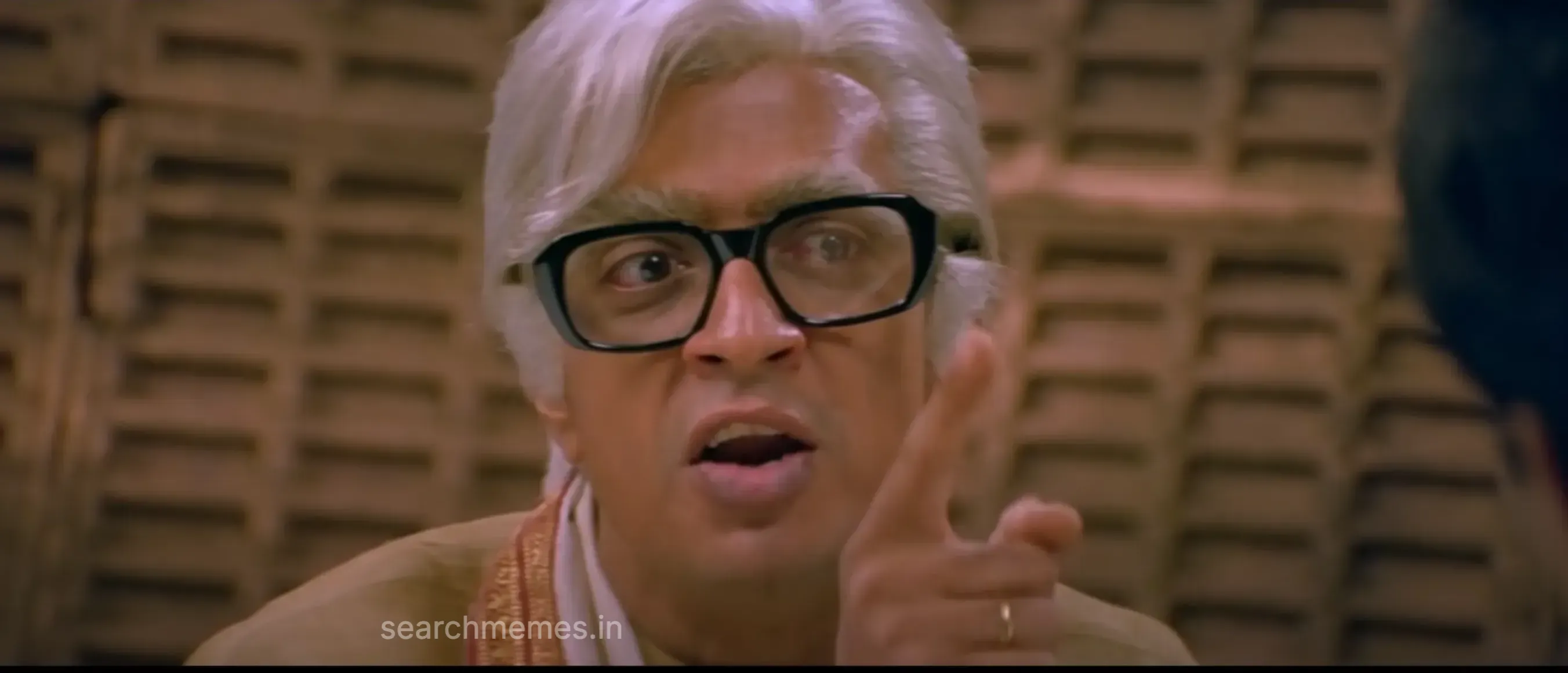 Raghuvaran gesturing sharply during an intense television challenge in Mudhalvan