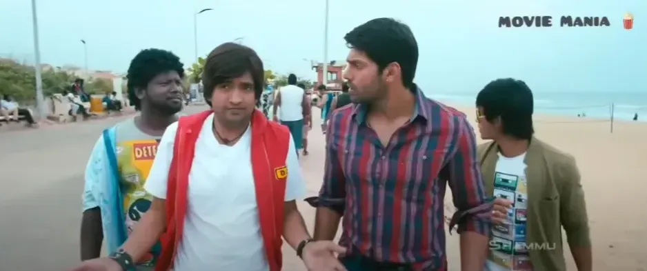 Santhanam looking anxious and gesturing urgently on a beach