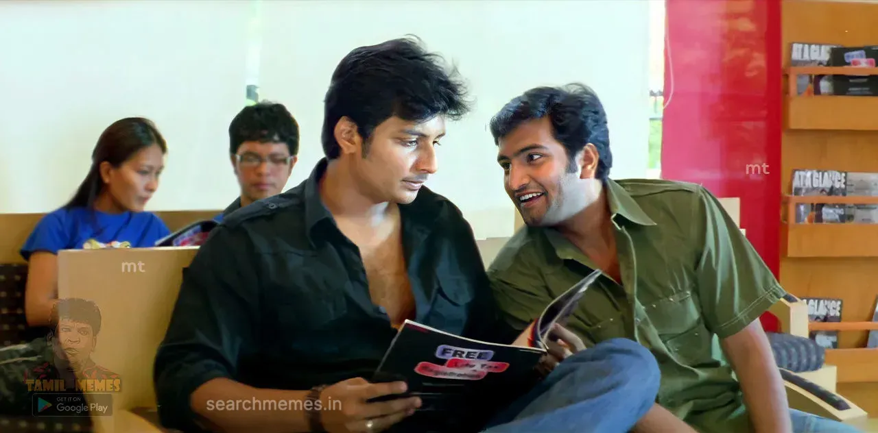 Jiiva holding an open magazine while Santhanam stares at him suspiciously