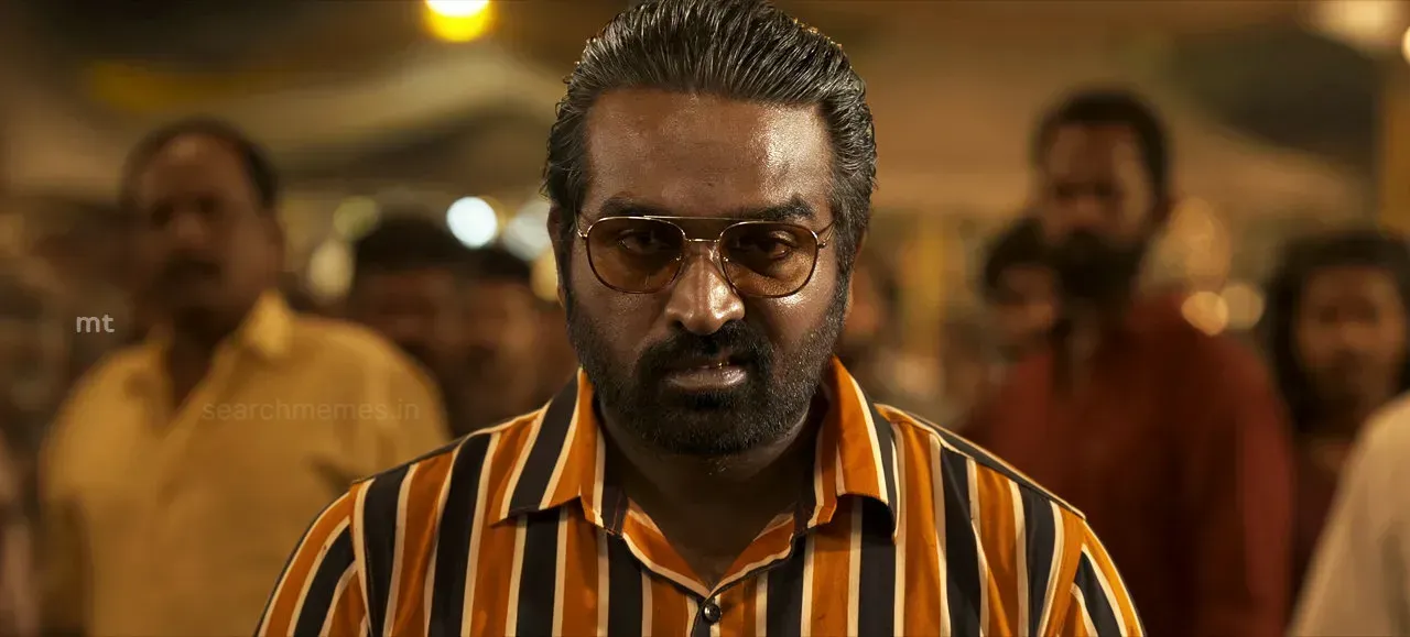 Vijay Sethupathi wearing tinted glasses and an intense glare in a crowd