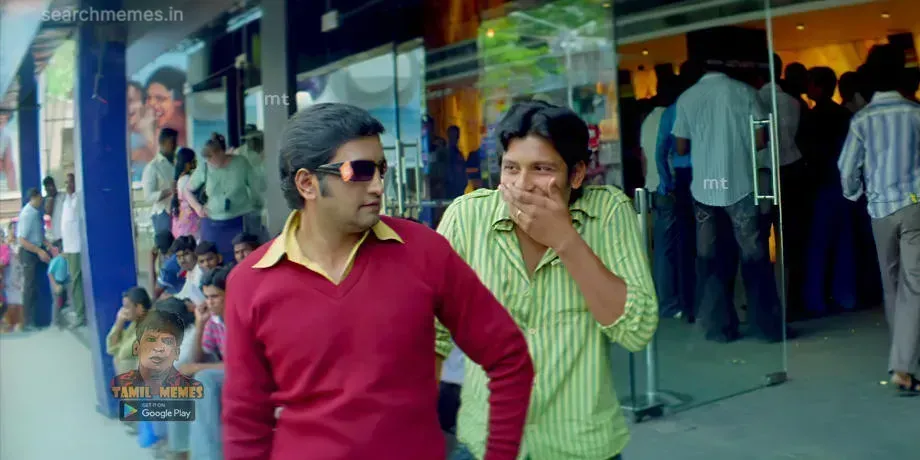 Jeeva laughing covering his mouth while Santhanam stands beside him in sunglasses