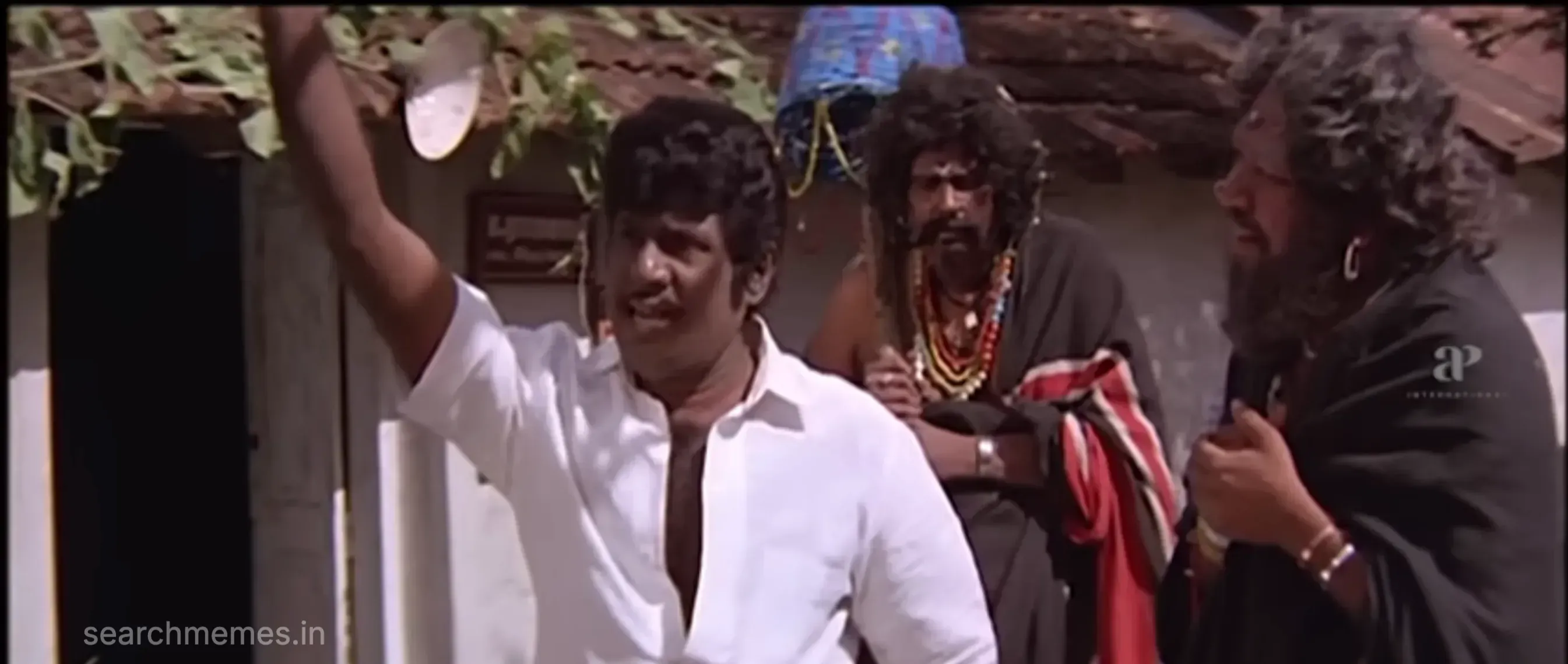 Goundamani speaking rapidly with animated expressions in an office
