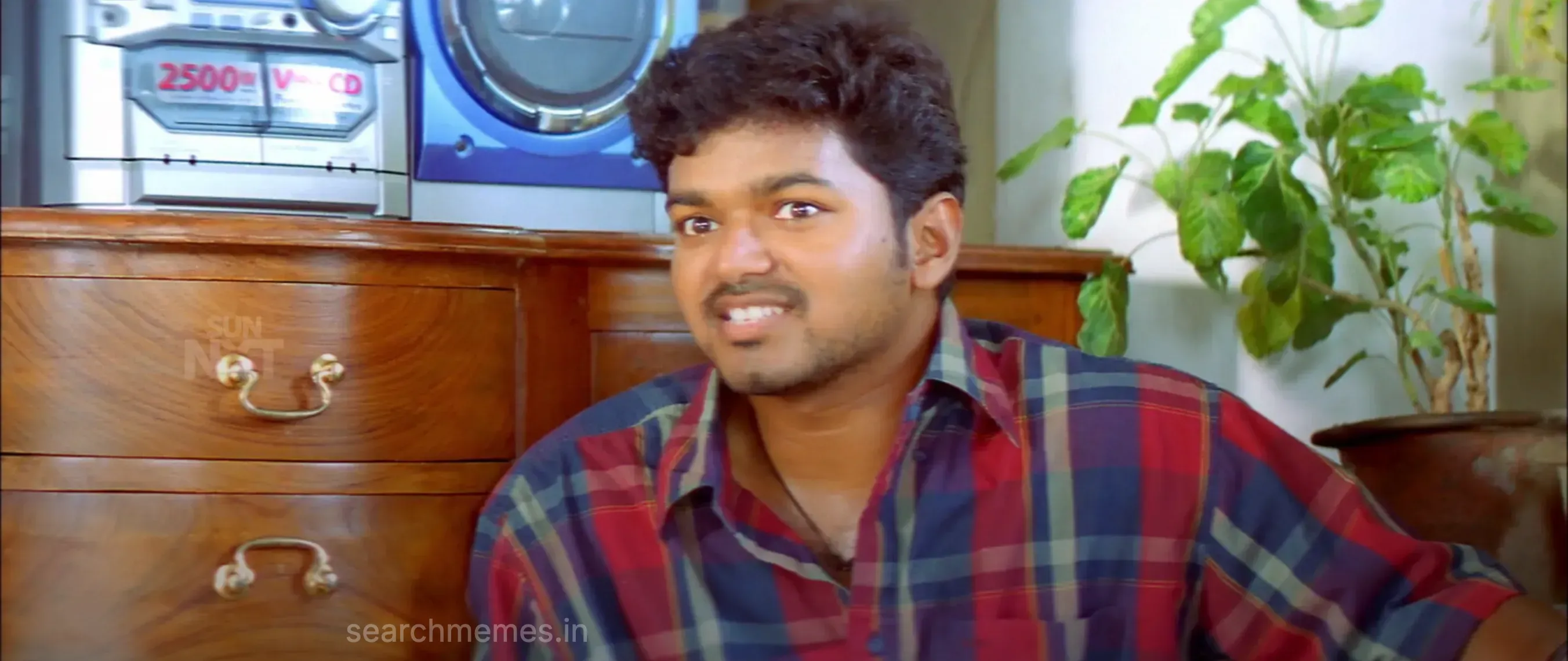 Vijay looking thoroughly irritated while forcing a grudging smile of thanks