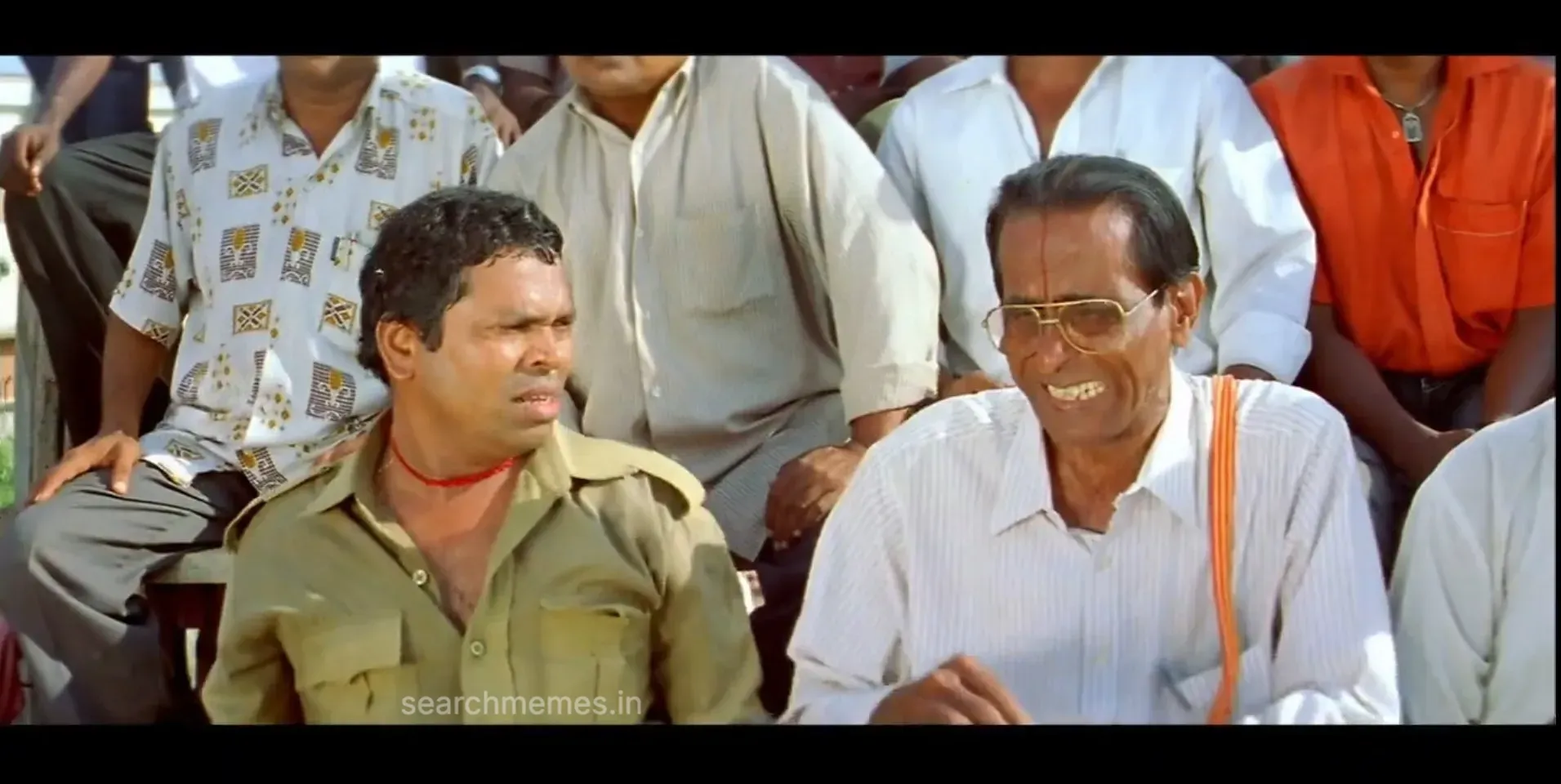 Mayilsamy resting his face in his hand looking profoundly bored and unimpressed