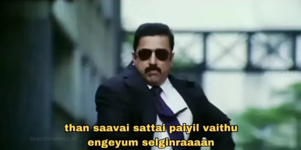Kamal Haasan in a suit and sunglasses walking purposefully in Vettaiyaadu Vilaiyaadu