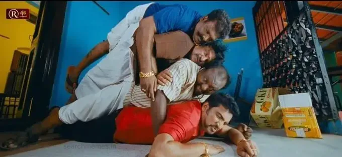 Four men comically piled one over another on the floor