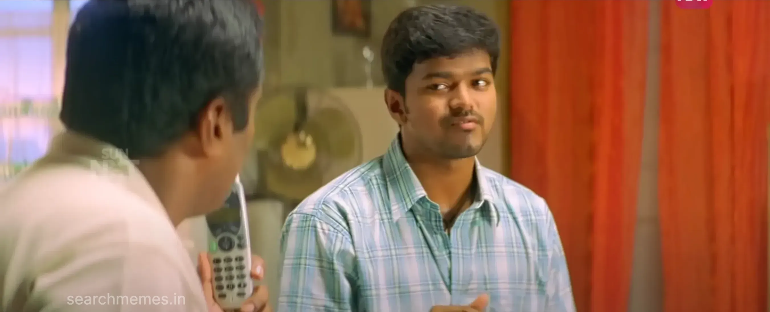 Vijay smiling with hands slightly raised in mock apology indoors