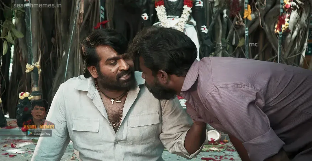 Vijay Sethupathi in grey shirt with a bead necklace smiling as a man leans in