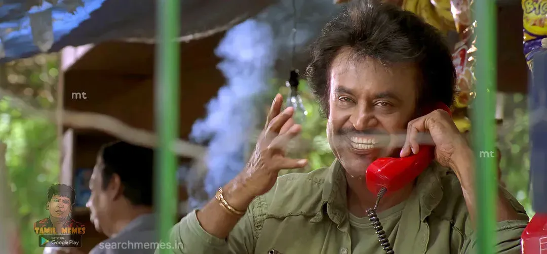 Rajinikanth smiling boldly while talking on a red wired telephone