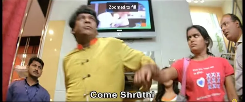 Vadivelu in a yellow kurta walking away with confidence while holding hands with someone