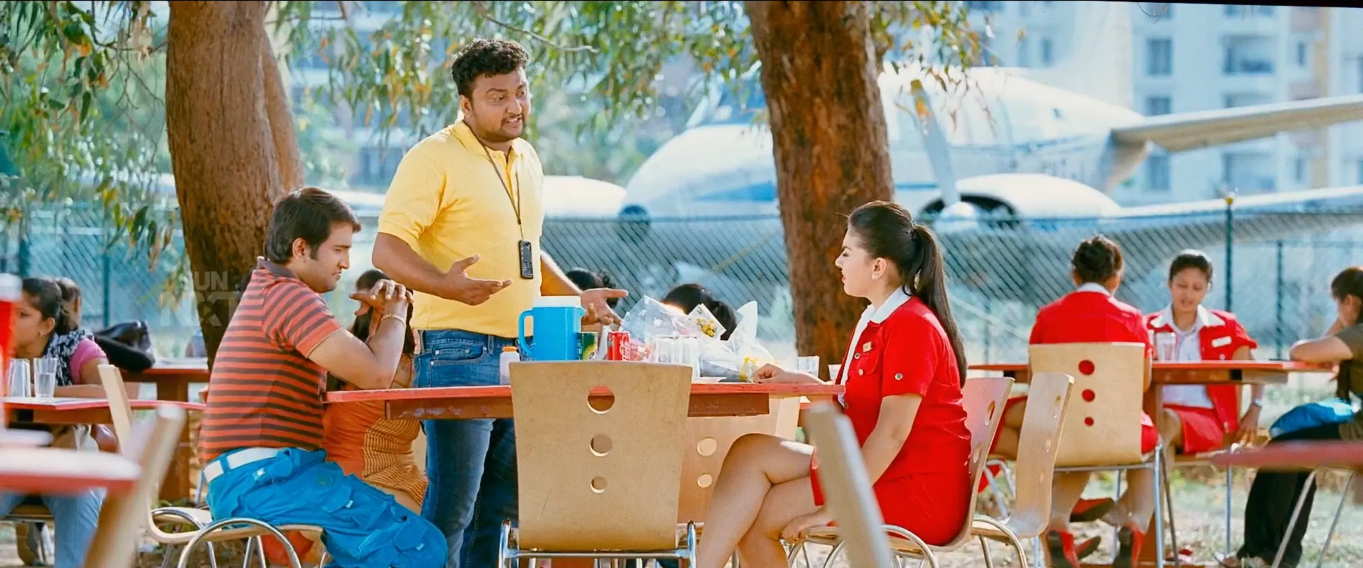 Santhanam at a mobile store counter gesturing anxiously to Hansika