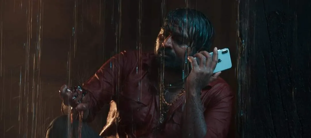 Vijay Sethupathi soaked in rain holding a smartphone to his ear in Master