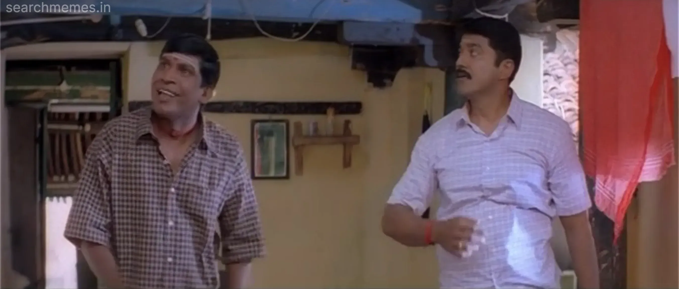 Vadivelu and Sarathkumar looking upwards towards the ceiling in confusion