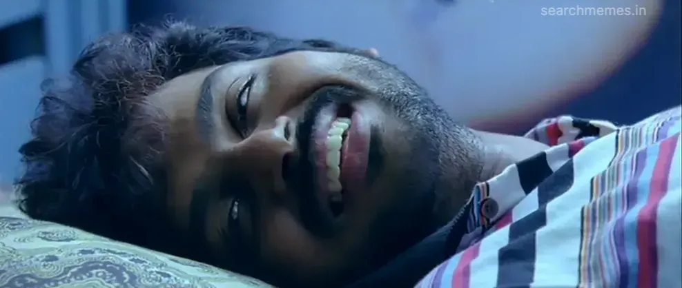Karthi lying on a bed with a drowsy happy morning smile