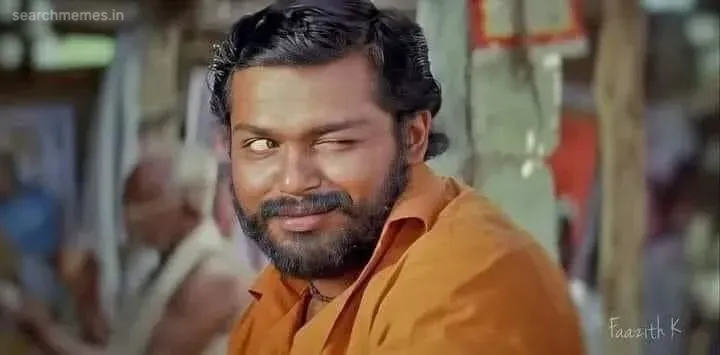 Karthi winking with a mischievous rustic smirk in rural attire