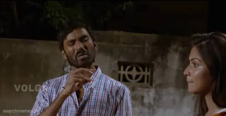 Dhanush making a gesture near his throat, looking slightly jealous while Amala Paul smiles next to him.