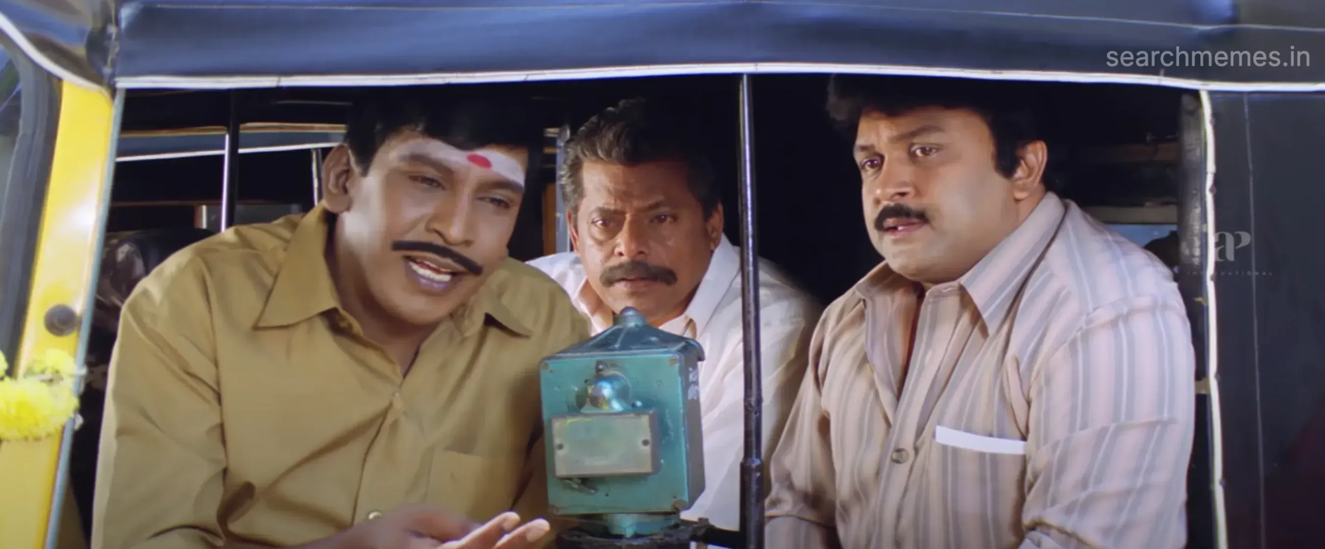 Vadivelu explaining with animated hand gestures to family members