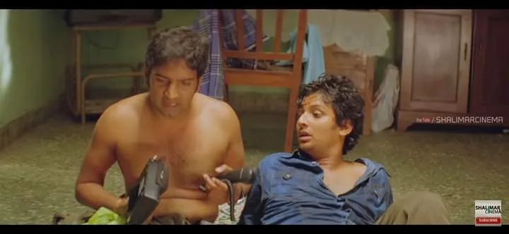 Santhanam looking frustrated while holding a broken telephone handset