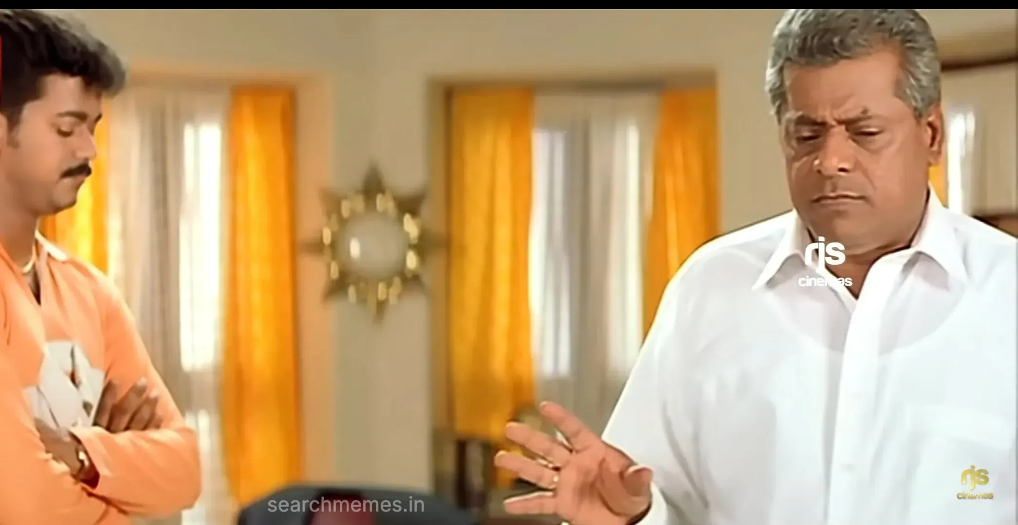 Delhi Ganesh gesturing with open palm while Vijay watches with folded arms in Tamizhan