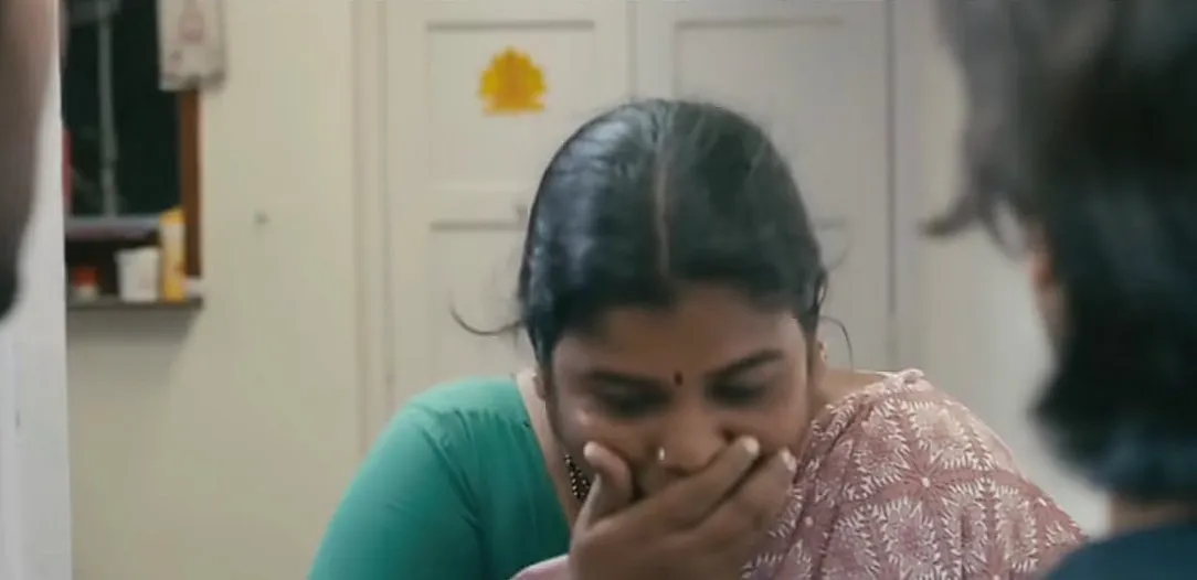 Santhanam struggling to suppress a laugh while looking sideways