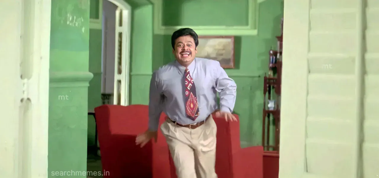 Madhan Bob rushing forward smiling with both hands raised enthusiastically