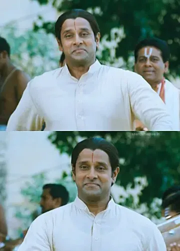 Vikram as Ambi in a traditional white outfit walking ahead with a smug expression
