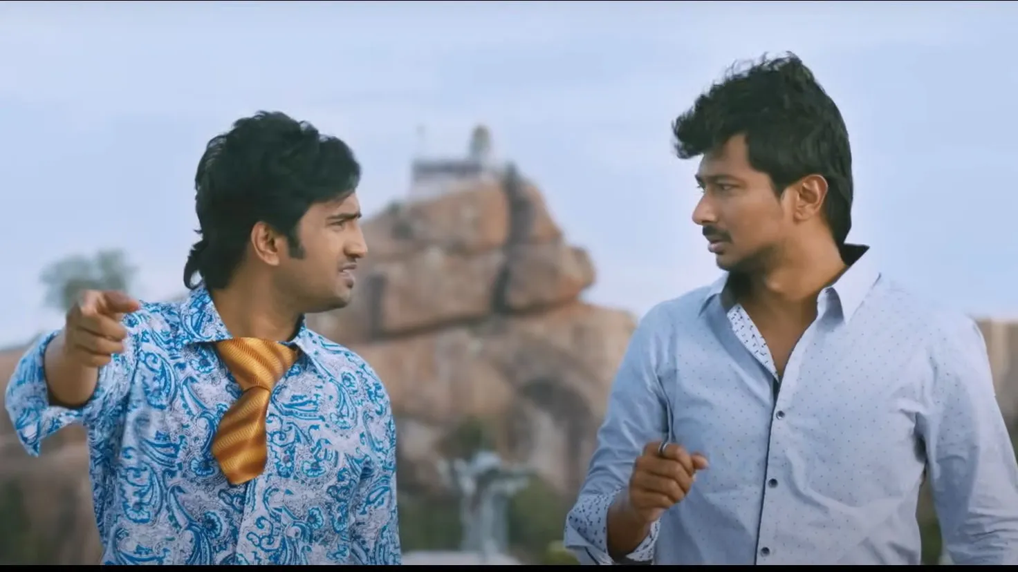 Santhanam pointing his finger aggressively while standing beside Udhayanidhi Stalin