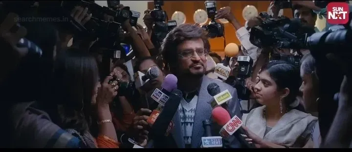 Rajinikanth as Dr. Vaseegaran speaking in front of microphones and journalists in Enthiran