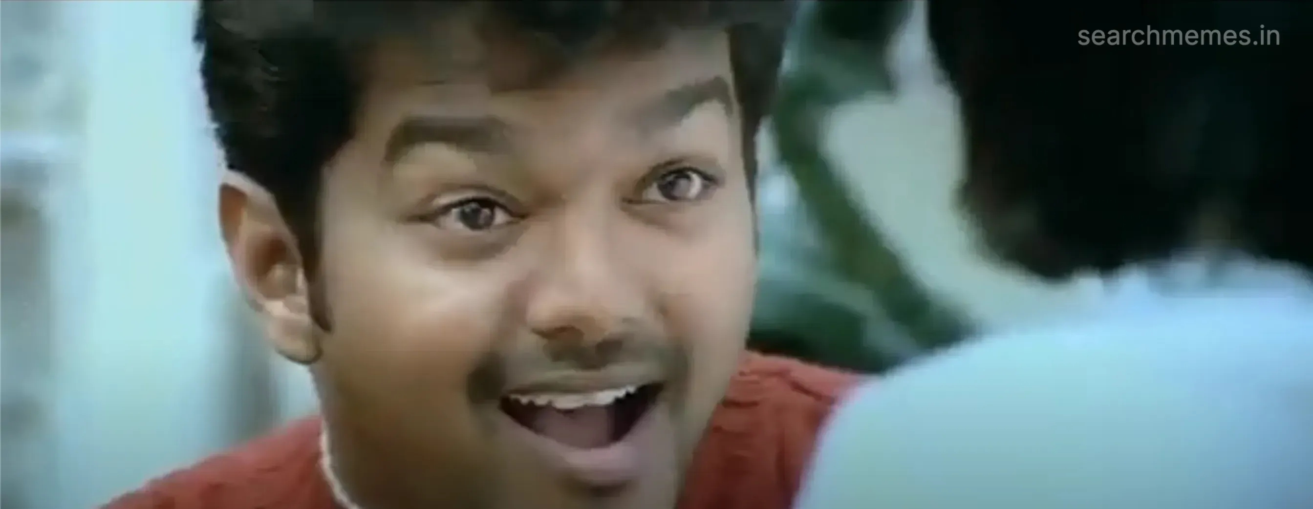 Vijay with a wide, surprised smile and bright eyes