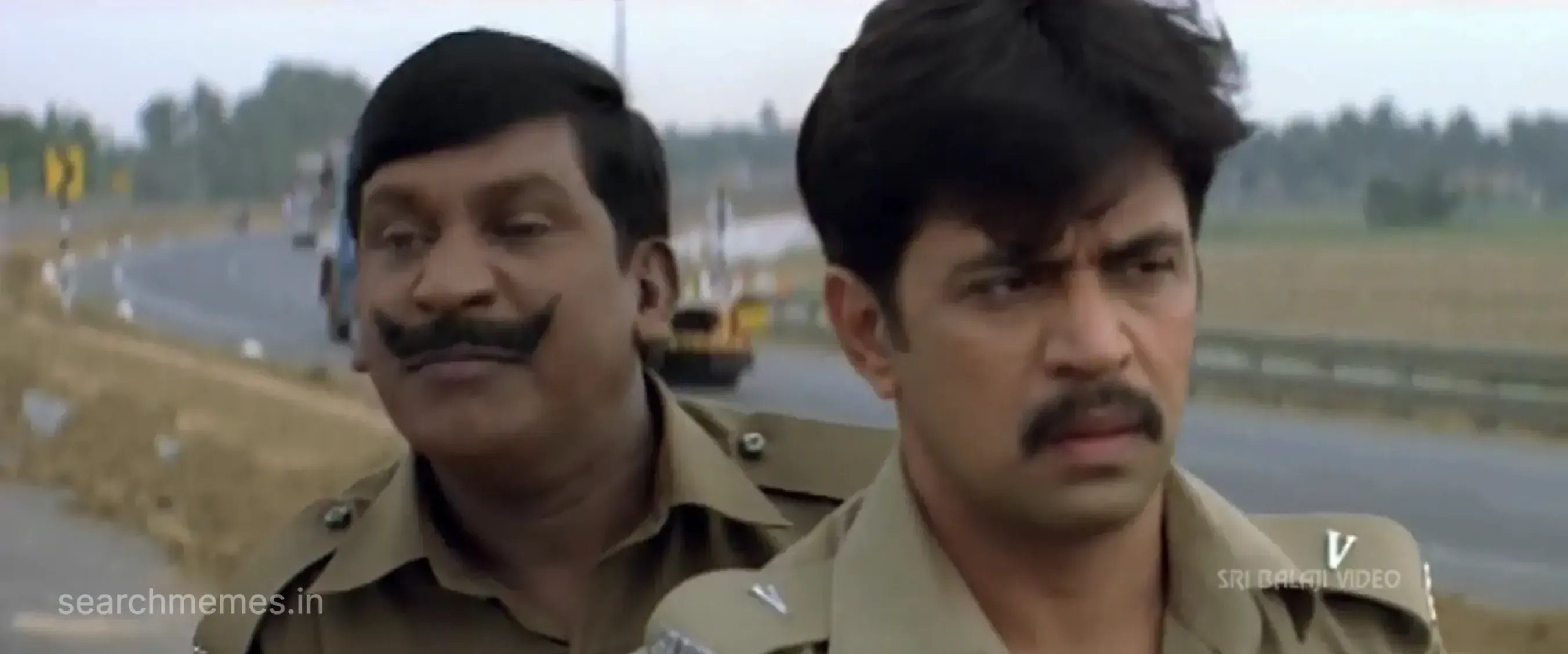 Vadivelu on a motorcycle behind a police officer making a weeping face