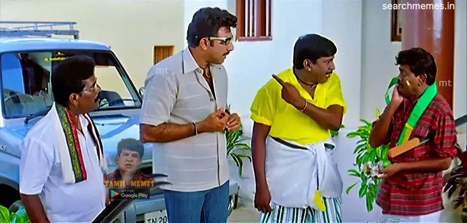 Vadivelu pointing an accusing finger while Sathyaraj and others stand beside a vehicle