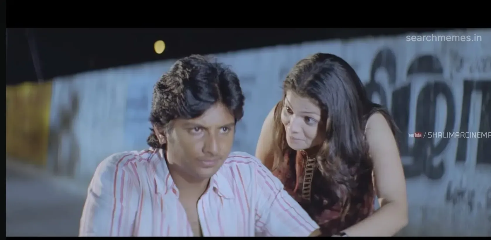 Jiiva leaning forward from his vehicle with a provocative teasing grin