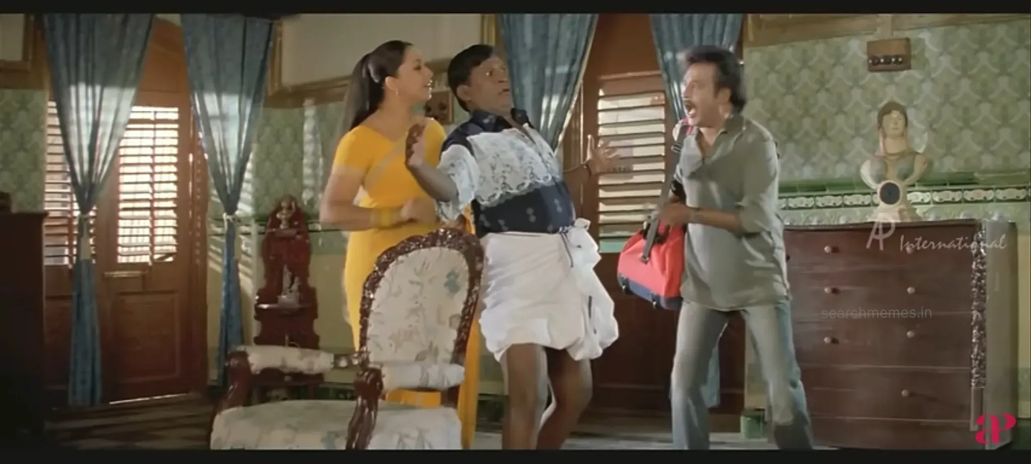 Vadivelu stretching both arms wide across a doorway with comical fierceness