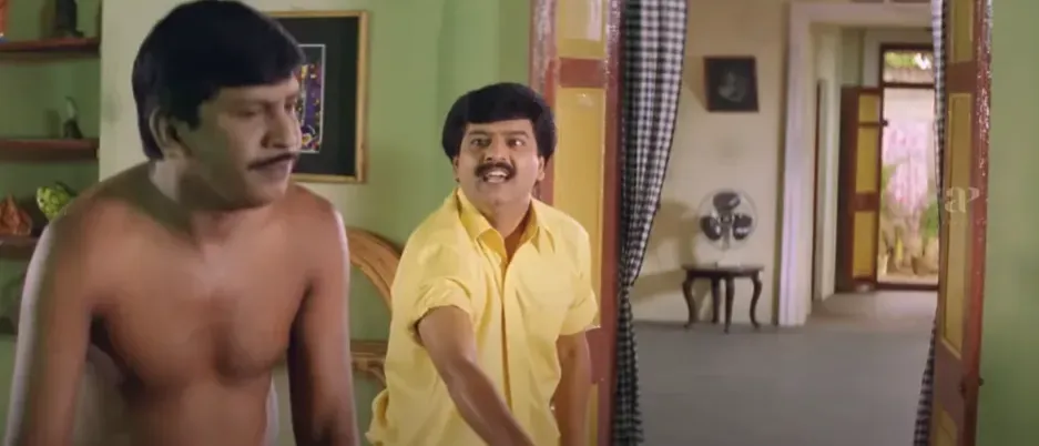 Vadivelu looking determined and gesturing defiantly toward the ground