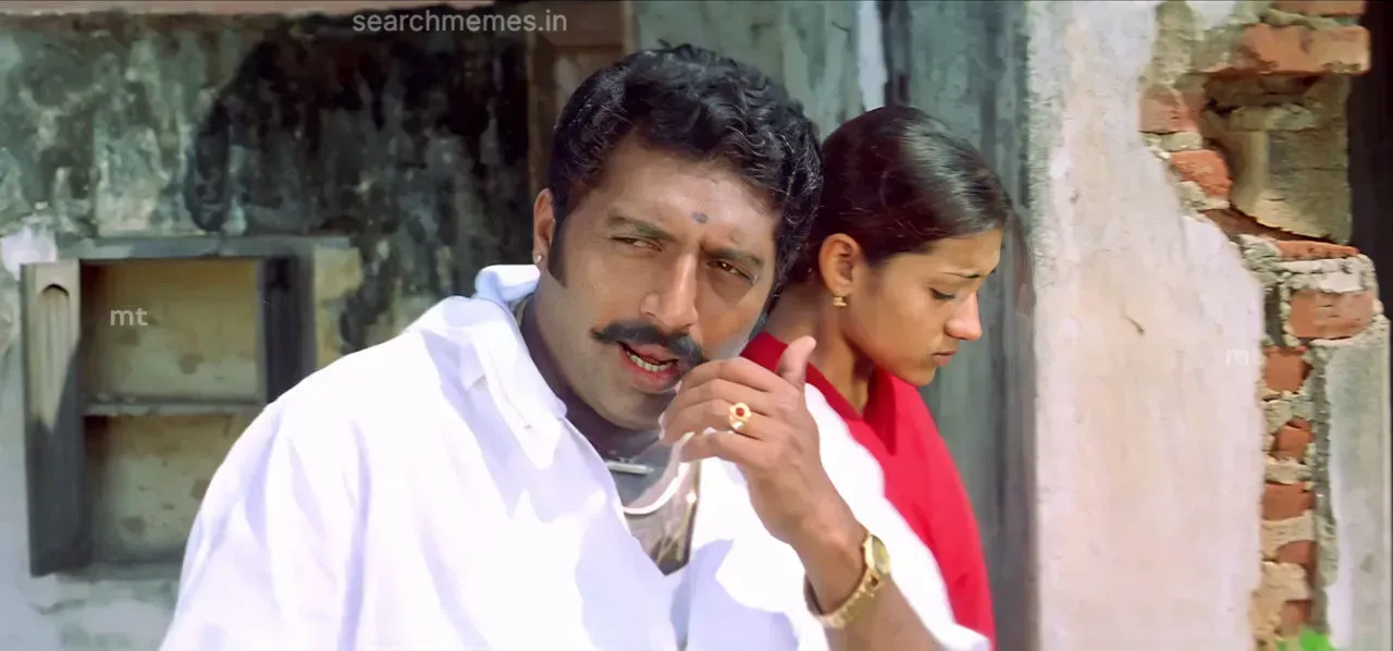Prakash Raj gesturing proudly next to Trisha in Ghilli